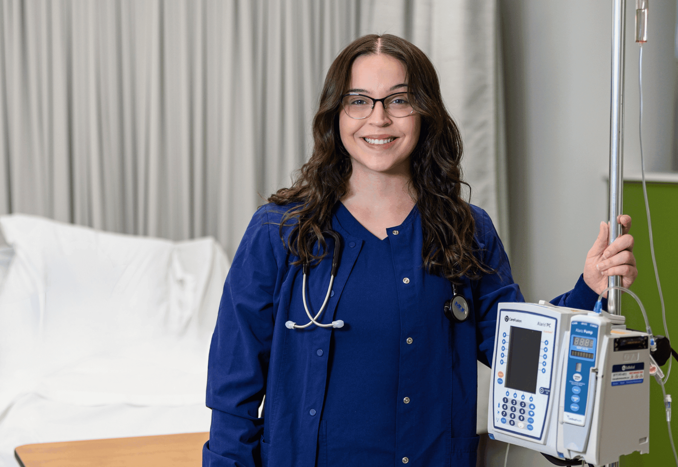 Portrait of student Abbie, holding on to a vital signs machine in the Nursing lab